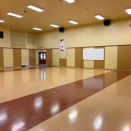large gymnasium with shiny floors, accreditation banner hanging on far wall