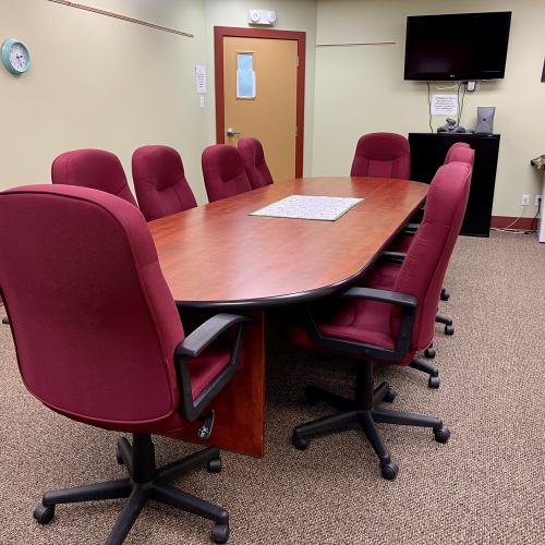 Kackaamin board room with redwood table, dark red chairs