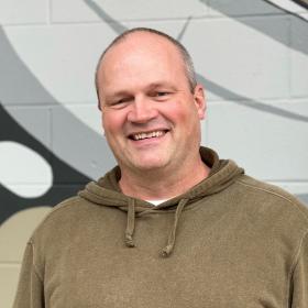 Marcel smiling and standing in front of Kackaamin gym