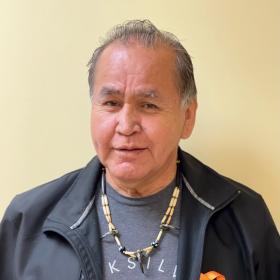 Walter smiling and standing in hallway against wall