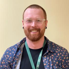 Aaron smiling and standing in hallway